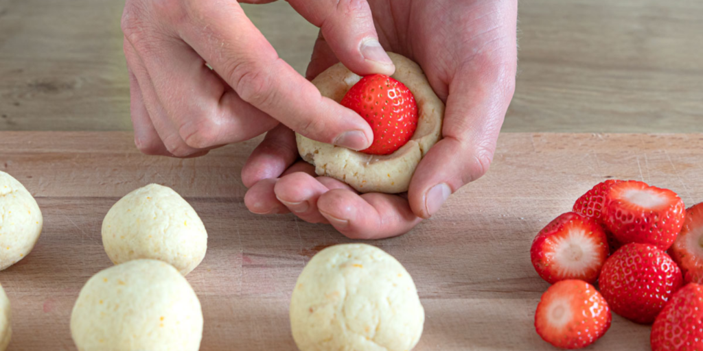Erdbeerknödel mit Quarkteig, mit saurer Sahne serviert - Rezepte &amp; Tipps