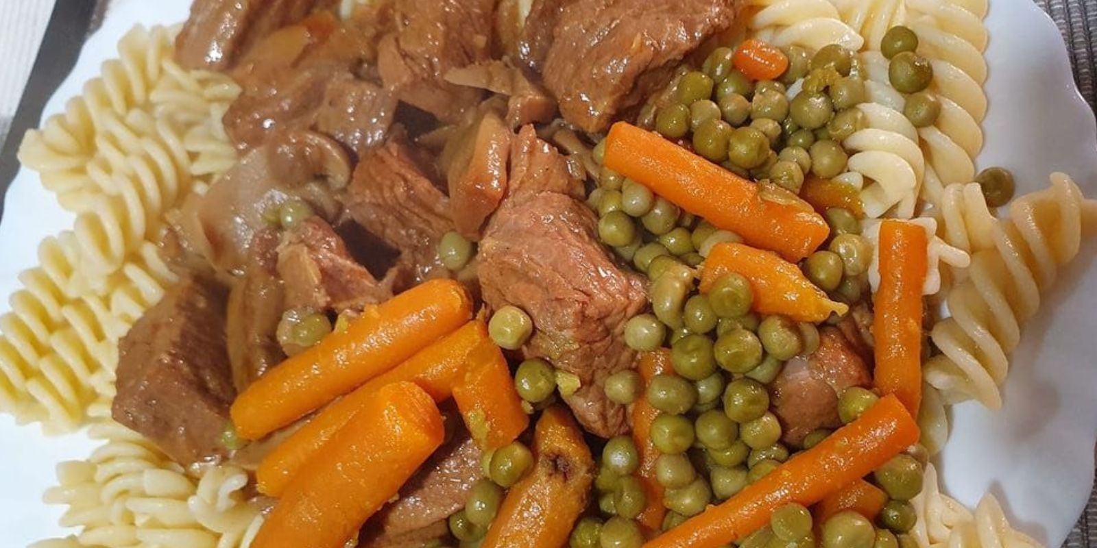 Herzhafter Genuss: Rinder Gulasch mit Nudeln, Erbsen und Möhren ...